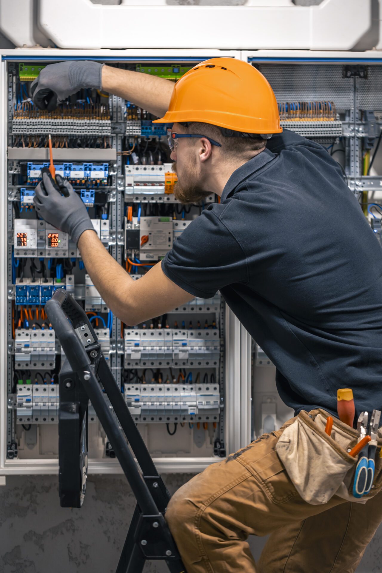 Male electrician working in a switchboard with fuses<br />
